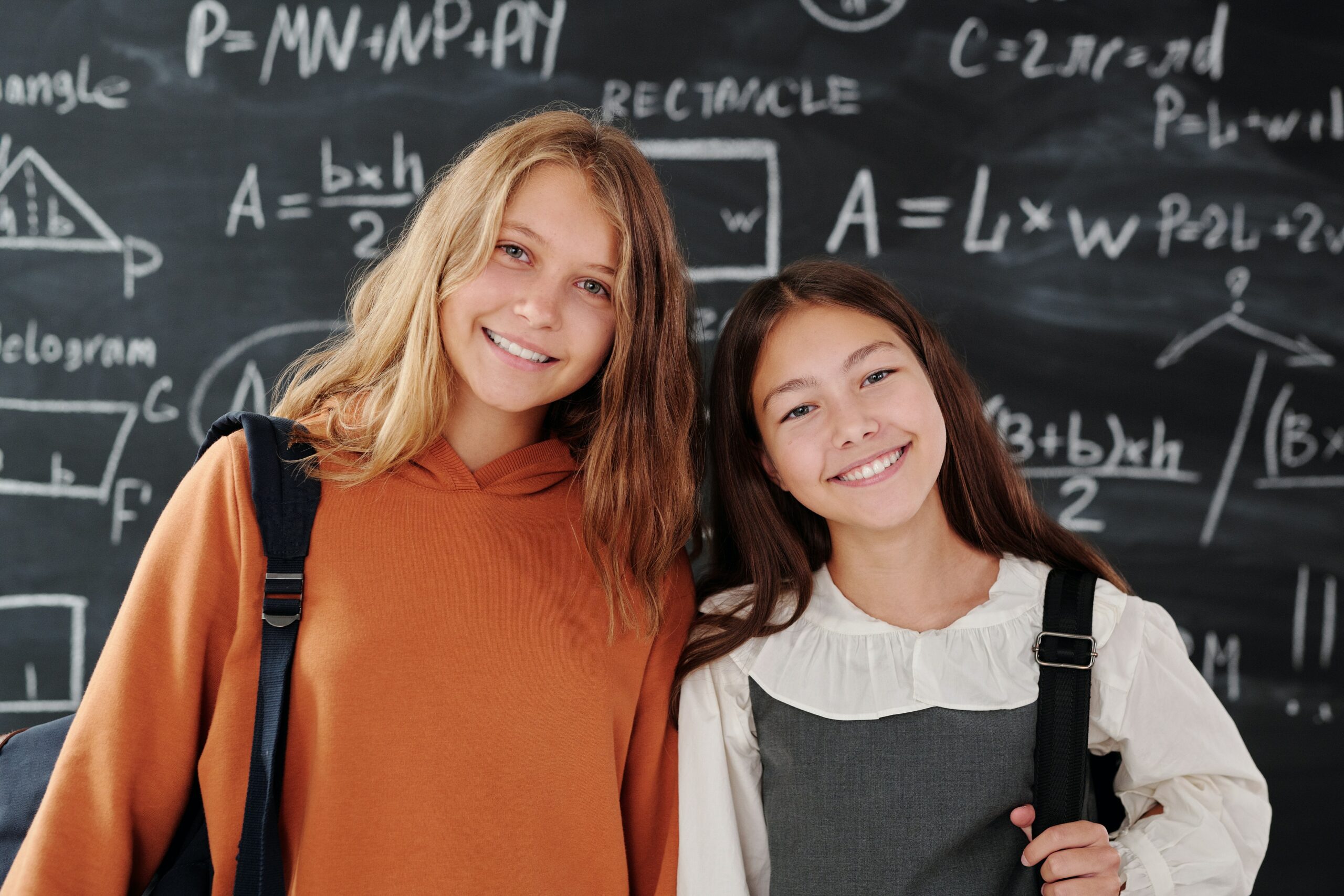 Students stand in front of the blackboard that has an algebraic equation